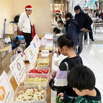 開催日：令和6年12月14日、15日
場所：イオンモールナゴヤドーム前
担当：地域貢献委員会

昨年に引き続きイオンモールナゴヤドーム前で「東区の魅力がいっぱい！笑顔あふれるクリスマスツリーフェスタ2024」を二日間に渡り開催。今年はイベントスペース２か所を借りてミニリース作りのワークショップを新設しスケールアップ！
東区9校の小学6年生の素敵な夢や想いが乗った巨大アルミ缶ツリーを2本展示、同じスペースにあるドアラツリーとともに迫力のあるツリーとなりました。

「ツリーコンテスト」では東区の企業、団体、学校からそれぞれの個性を活かしたツリーを全部で17本出展してもらい、来場者に投票してもらうコンテストを実施しました。毎年各ツリーともレベルアップしてとても個性豊かで煌びやかなスペースとなり多くの方に楽しみながら投票してもらいました。

イオンに来場された方も立ち並ぶクリスマスツリーを見て立ち止まって見入る方も多くいらっしゃいました。多くの方に喜んでもらえるイベントとして年々成長していることを実感しました。